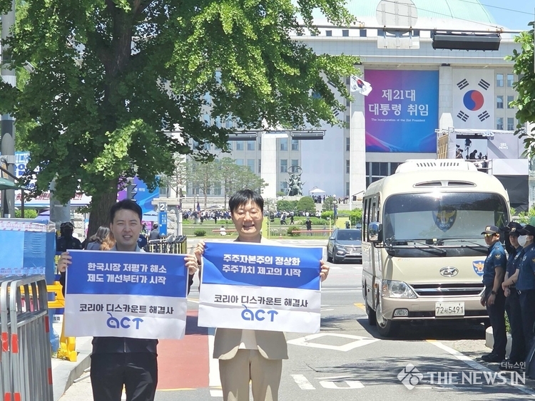 사진: 주주행동 플랫폼 액트의 이상목 대표(좌) 및 윤태준 소장(우)이 대통령 취임식이 열리는 국회 인근에서 '한국시장 저평가 해소 제도 개선부터 시작', '주주자본주의 정상화 주주가치 제고의 시작' 등의 문구가 적힌 피켓을 들고 상법 개정을 촉구하고 있다. (출처 : 주식회사 컨두잇)
