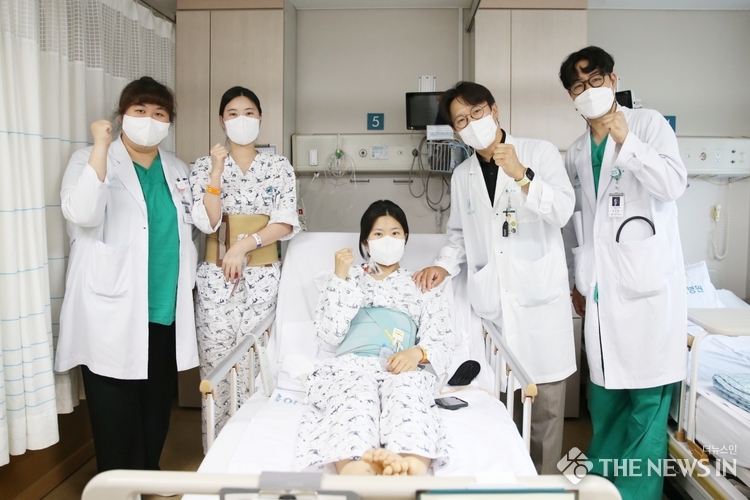 다낭성 신증후군으로 만성 신부전을 앓던 이가영 씨(가운데)가 로봇 신장이식 후 순조롭게 회복하며 20일(금) 의료진과 기념사진을 찍고 있다. 왼쪽에서 두 번째가 공여자인 언니 이 모 씨, 네 번째가 수술을 집도한 서울아산병원 신·췌장이식외과 신성 교수.